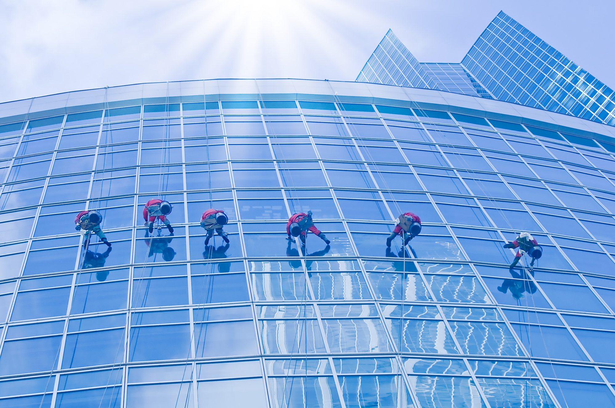 Employé nettoyant les vitres d'une façade d'immeuble de bureaux et locaux professionnels / Washers wash the windows.